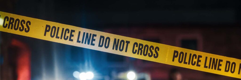 Crime Scene at Night: Crime Scene Investigation Team Working on a Murder. Female Police Officer Briefing Detective on the Victim's Body. Forensics and Paramedics Working. Cinematic Shot